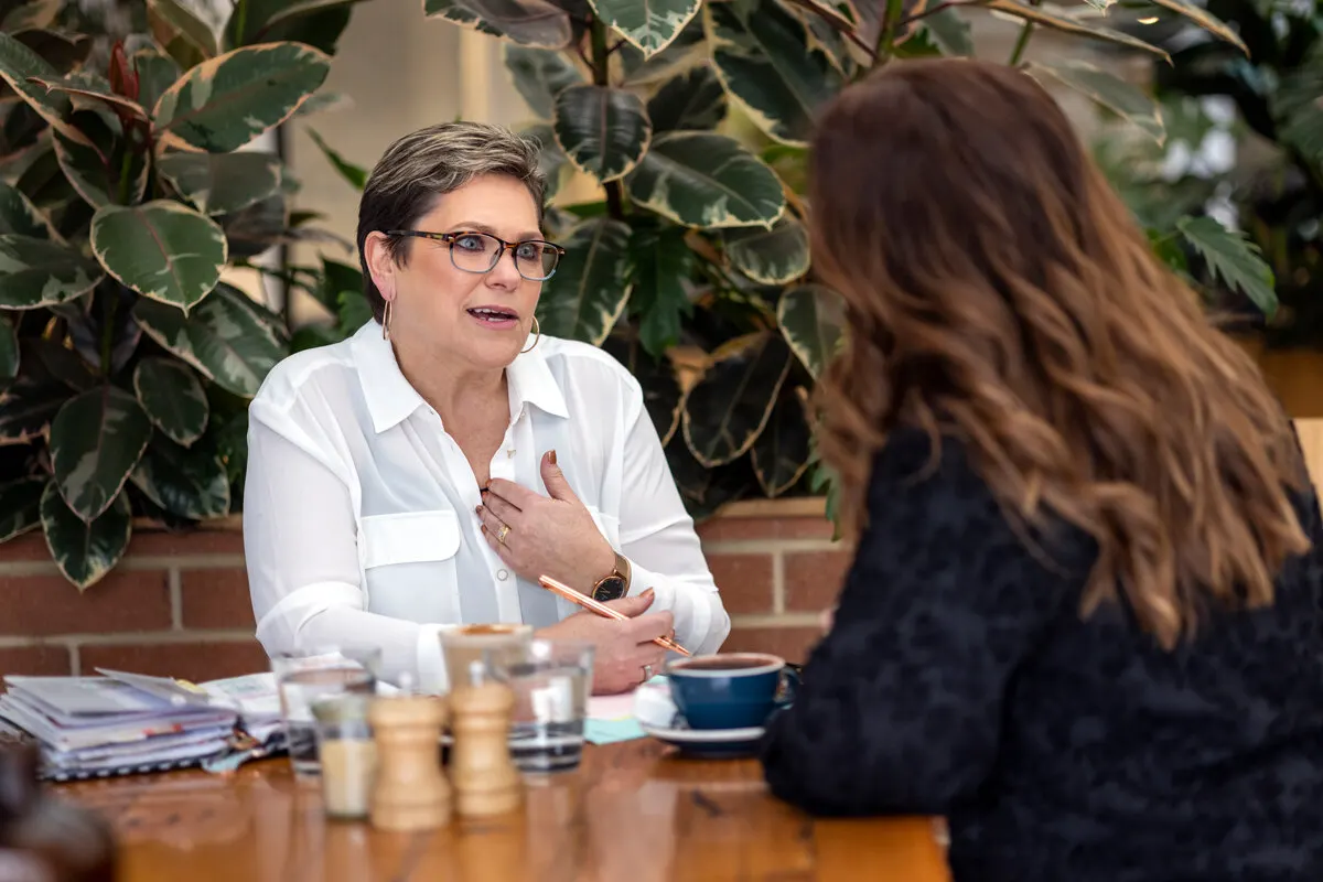 Sue mid-conversation with a client over coffee during a coaching session