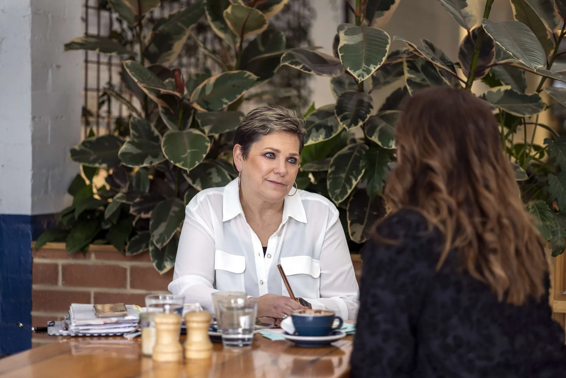 Sue listening to a client over coffee