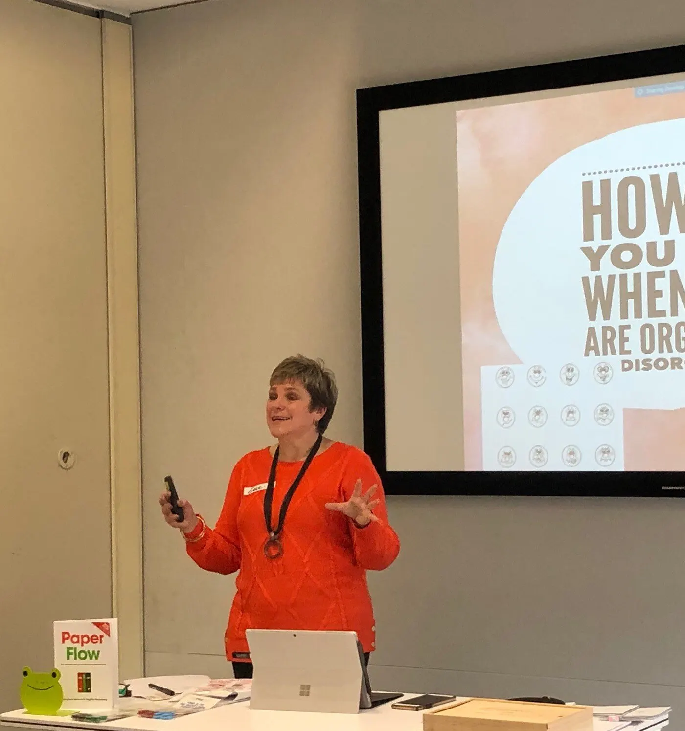 Sue presenting in an orange top